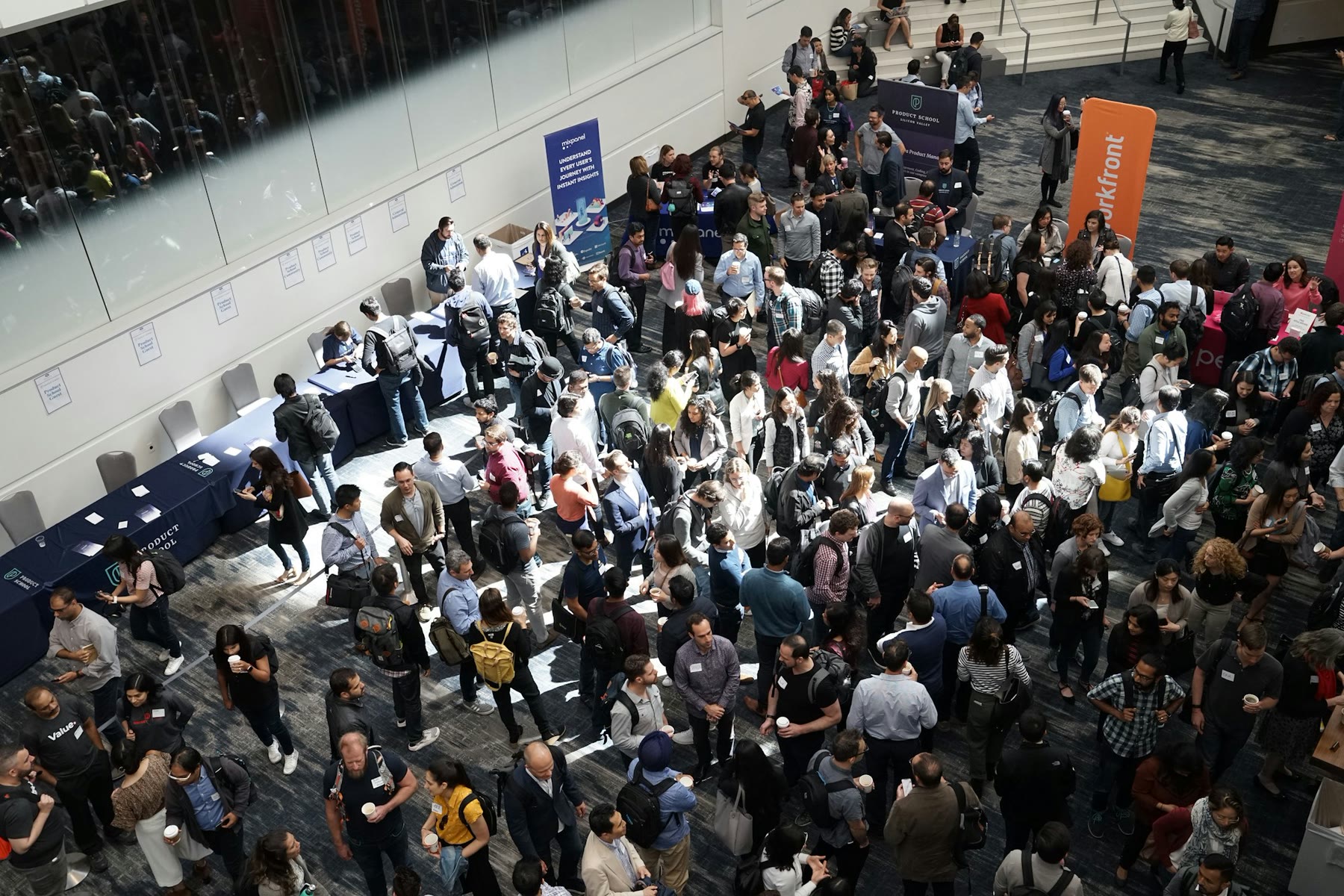 Attendees standing and talking in a crowded conference lobby.